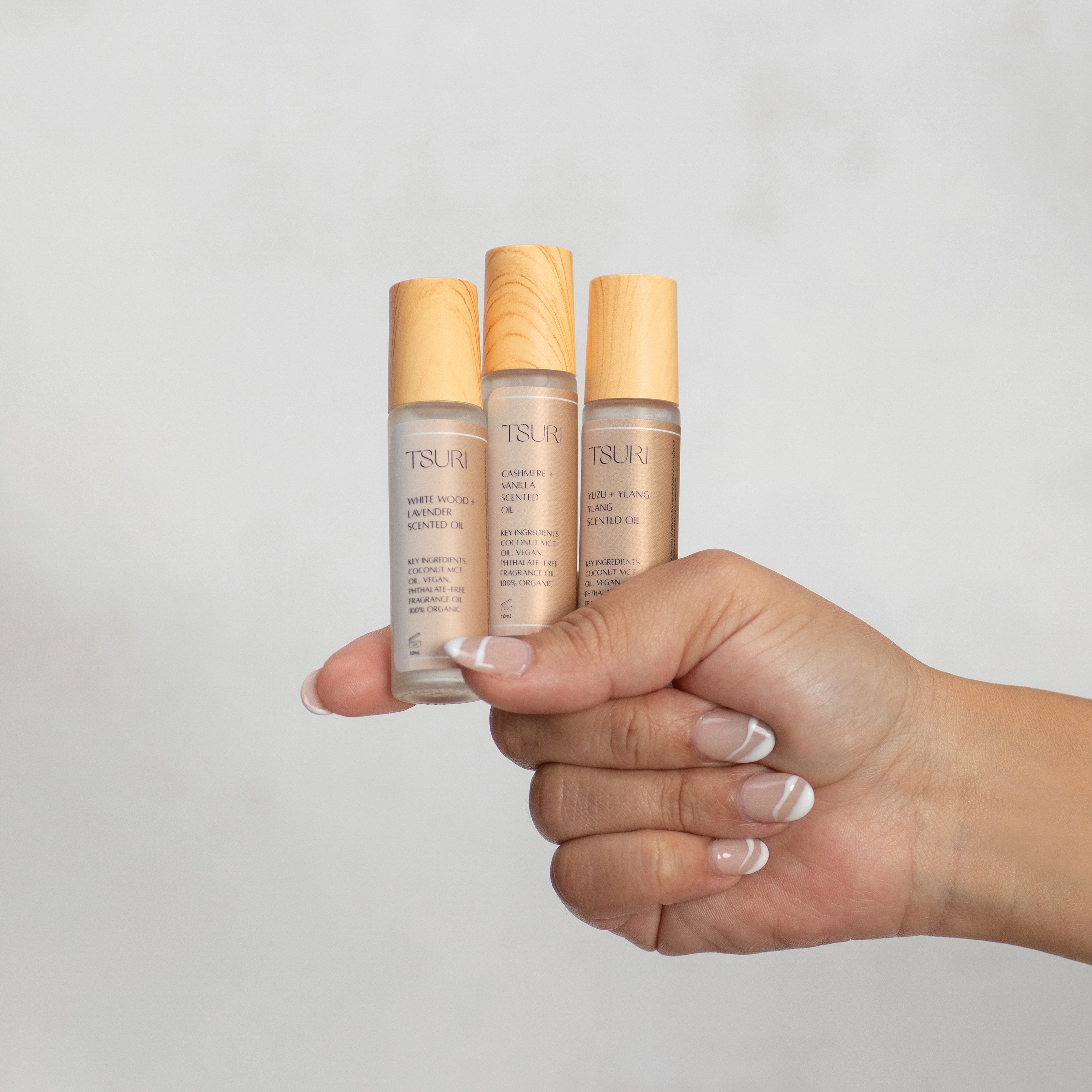 Alt Tag: Hand holding bottles of vegan Cashmere + Vanilla scented oil, featuring elegant design and eco-friendly packaging, 10 mL each.