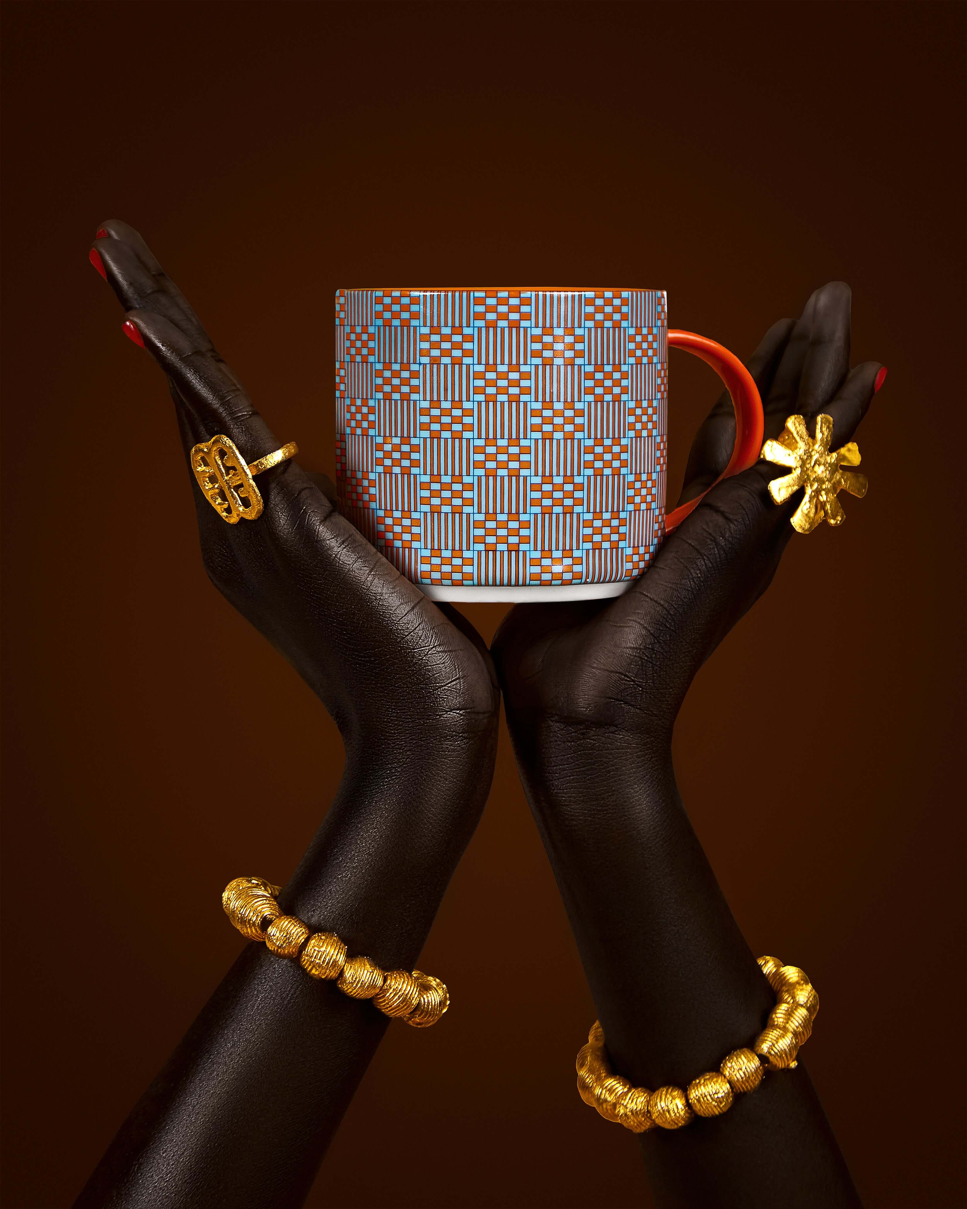 Orange Oasis mug held between elegant hands, showcasing vibrant design and craftsmanship from the Kentemania Collection.